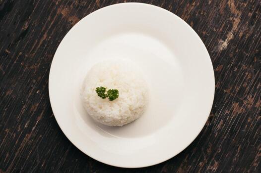 Overhead View of Plain White Rice with Parsley Garnish on a White Plate photo