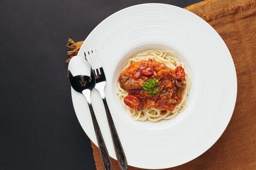 Overhead View of Spaghetti with Tomato Sauce and Basil on a White Plate photo