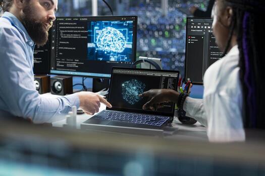 Team leader teaching intern to code in data center, updating AI automation scripts. Server room supervisor guiding trainee during internship, programming artificial intelligence algorithms photo