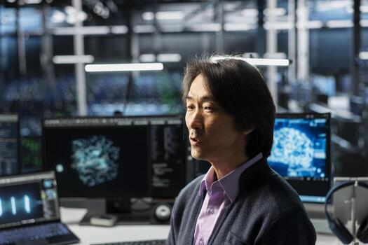 Programmer in data center optimizing infrastructure for AI tasks, increasing workloads. Asian employee in server room automating system diagnostics using deep learning predictions photo