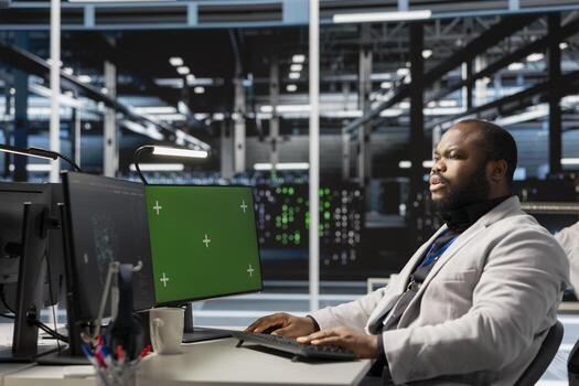 Data center software developer monitoring system performance using green screen mockup PC, identifying bottlenecks. Server farm IT expert troubleshooting bugs using chroma key computer photo