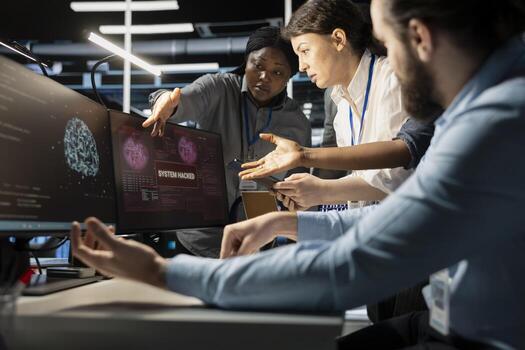 Programmers in AI data center reacting to virus alert, initiating protocol to protect critical systems. Server room IT experts doing brainstorming, assessing compromised gear after hacker attack photo