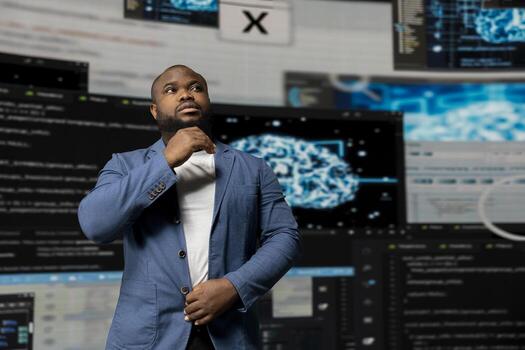 African American IT engineer analyzing programming language for automation, data science with a futuristic interface behind him. Male tech professional thrives with AI and code snippets. photo