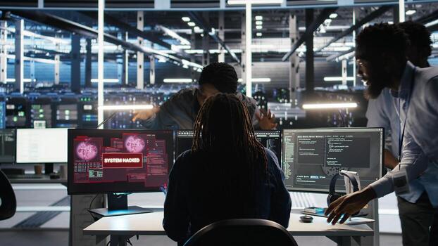 Cybersecurity team in data center responds to security breach, trying to prevent unauthorized access. Workers rushing to secure servers and protect sensitive information during cyberattack, camera A photo