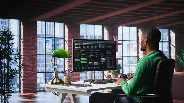 African american engineer at home working on visual coding on terminal window, typing programming language and reviewing the notes tree. IT expert using debugging algorithms to fix errors. Camera B. photo