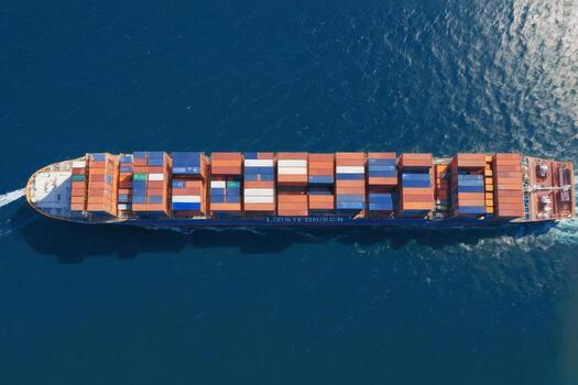 Large container ship sailing on a clear summer day on the open sea. Enface view from above photo