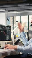 Vertical Investment consultant talking in headset mic, reviewing client portfolio performance. Trader discussing with customer, forecasting financial growth and providing tailored strategy, camera A video