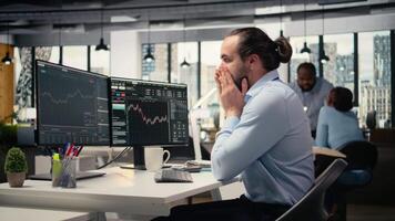 Trader covering face in disbelief, concerned by investment portfolio value drop after unexpected market crash. Upset financial expert distressed by stock exchange account losses, camera A video
