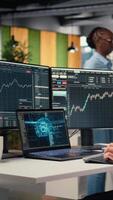 Vertical Stockbroker using deep learning technology on laptop to assess stock market volatility. Prop firm worker using AI assistant software on notebook to evaluate portfolio analytics reports, camera A video