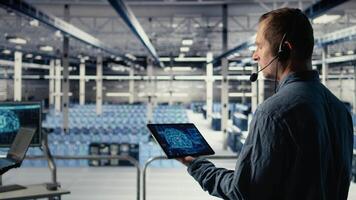 dati centro ingegnere utilizzando ai su tavoletta per Aiuto clienti risolvere sito web ospitando i problemi. server centro Tech supporto specialista porzione utenti mantenere loro in linea Servizi in esecuzione dolcemente, telecamera un' video