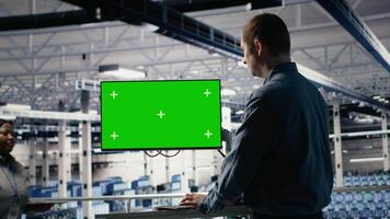Server farm technician using green screen computer to scan hardware rigs for issues. Data center IT specialist on industrial platform uses mockup PC to schedule file backups, camera B video