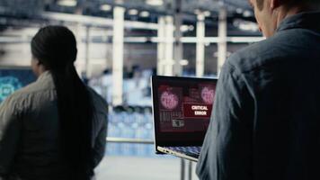 Server hub programmer alerted by warning message about bugs causing infrastructure slowdowns. Data center IT expert sees system popup about low hardware performance caused by software bugs, camera B video