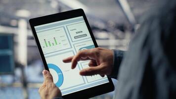 stänga upp av data Centrum anställd kontroll infrastruktur diagnostik grafer på läsplatta skärm. den specialist på industriell plattform i server rum granskning data diagram under systemet granska, kamera b video