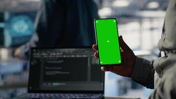 engenheiro usando isolado tela Smartphone dentro servidor quarto enquanto otimizando profundo Aprendendo sistemas tratamento tarefas. dados Centro trabalhador usa croma chave Móvel telefone, ajustando ai modelo parâmetros, Câmera b video