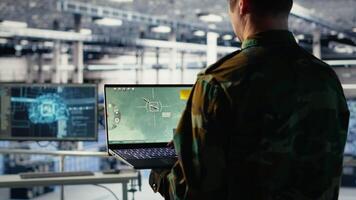 Army specialist in data center integrating AI into radar systems for missile tracking. Military soldier in server room analyzing aerial movement through artificial intelligence systems, camera B video