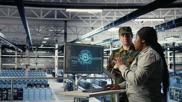 Military staff in server room uses AI tools to help manage computer systems. Army team wearing uniform reviews information using artificial intelligence programs in server farm, camera A video