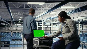 esso collaboratori monitor server azienda agricola attività utilizzando isolato schermo il computer portatile. dati centro ingegneri revisione impianti di perforazione test risultati su croma chiave taccuino per garantire sistemi siamo Lavorando correttamente, telecamera un' video