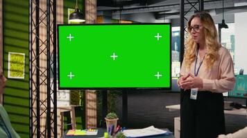 Manager and staff members using copy space on TV monitor during meeting, presenting charts and data reports for a development plan. Strategic work environment for growth. Camera A. video
