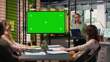 kvinna medarbetare team använda sig av isolerat TV övervaka till Stöd de företag genomgång möte, omgiven förbi modern teknologi och produktivitet verktyg. utskjutande tillväxt metrik och framtida mål. kamera a. video
