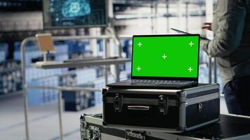 Close up of isolated screen laptop in front of data center programmers improving AI rigs processing speed. Server hub coworkers manage gear using chroma key device to support AI workloads, camera B video