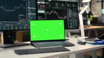cerca arriba de verde pantalla ordenador portátil y comercio aplicación en activo administración empresa oficina. Bosquejo dispositivo en escritorio usado por corretaje firma trabajadores rastreo valores intercambiar actividad utilizando analítico herramientas video