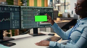 suporte empresa estagiário dentro escritório aprende Novo negociação estratégias a partir de lição em verde tela Móvel telefone. corretagem companhia estagiário usando croma chave Smartphone para Assistir educacional contente, Câmera uma video