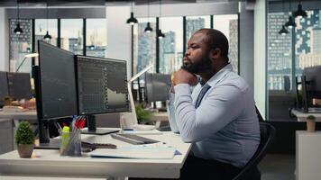 día comerciante análisis valores mercado precio gráficos, haciendo pensamiento, haciendo comprar y vender decisiones en apuntalar firma oficina. hombre haciendo lluvia de ideas, colocación cliente pedidos utilizando comercio plataforma, cámara un video