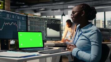 stötta fast näringsidkare i kontor lär ny handel strategier från lektion på isolerat skärm bärbar dator. afrikansk amerikan kvinna i forex företag använder sig av attrapp anteckningsbok, kamera en video