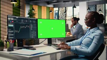 día comerciante en corretaje oficina análisis valores mercado cartas en verde pantalla ordenador personal, haciendo comprar y vender decisiones financiero experto lugares cliente pedidos utilizando comercio software en croma llave ordenador personal, cámara un video
