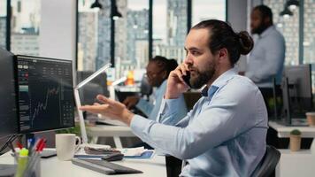 Investment consultant talking in telephone call with client, reviewing portfolio performance. Trader using smartphone to do phone call with customer, providing financial strategy, camera B video
