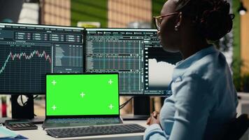 stötta fast näringsidkare i kontor lär ny handel strategier från lektion på isolerat skärm bärbar dator. afrikansk amerikan kvinna i forex företag använder sig av attrapp anteckningsbok, kamera b video