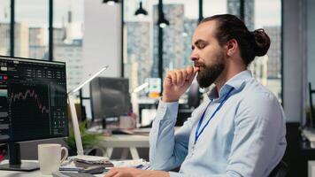 comerciante en oficina clausura ojos a hacer soñador, visualizante financiero independencia y futuro éxito. alegre apuntalar firma empleado a escritorio perdido en pensamiento, imaginando próspero comercio, cámara si video