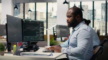 Teamworking traders in office work together to resolve security alert after hacker uses exploit to penetrate systems. Team of prop firm colleagues brainstorm how to protect from cyberattack, camera B video