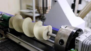 en cnc maskin är träsnideri en komplex spiral form från en plast blockera, en symbol av modern industriell teknologi video