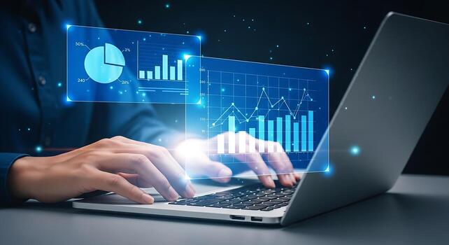 Close up of hands typing on a laptop with glowing blue digital data analytics and charts projecting upwards in a modern office. photo