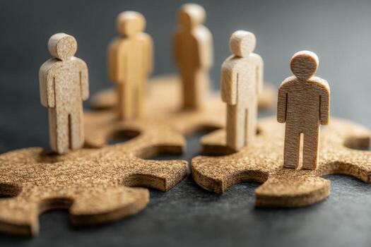 Collaborative teamwork with wooden figurines on puzzle pieces representing connection and unity photo