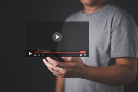 A man hold a smartphone with a digital live streaming interface overlay. The screen displays a play button and progress bar, symbolizing online media, cyberspace interaction, and real time streaming. photo