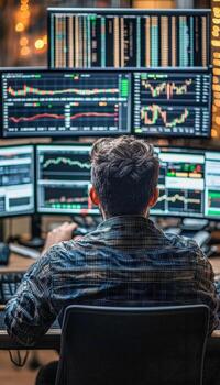 Stock trader analyzing multiple computer screens with financial data and market graphs photo