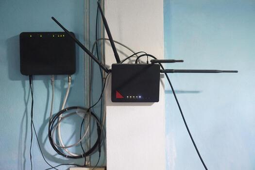 Wireless router and modem installed on a wall, distributing high-speed internet via Wi-Fi. Essential technology for home and office networks, enabling connectivity, online communication, smart devices photo