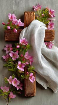 Wooden Cross Adorned With Pink Cherry Blossoms on a Soft Fabric Surface During Springtime. photo