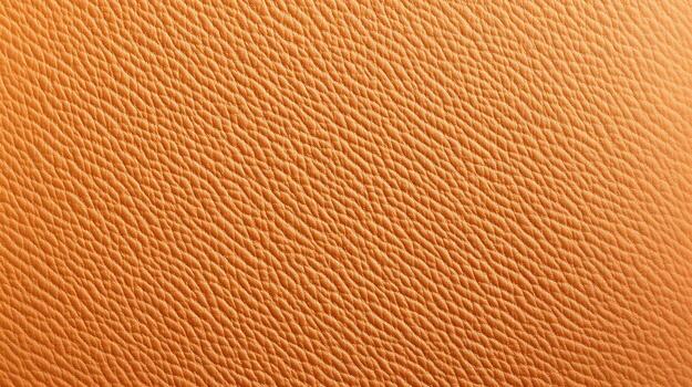 An elegant tan leather texture fills the frame displaying its natural grain and subtle surface variations. photo