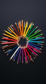Colorful arrangement of colored pencils in circular pattern photo