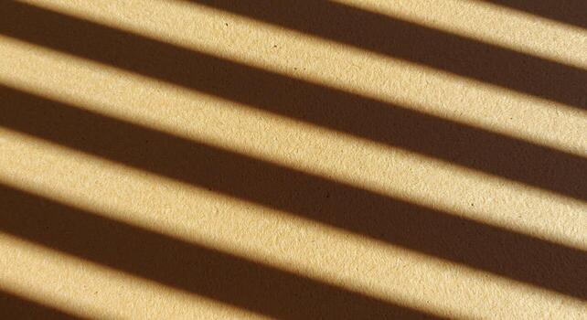 Golden Light and Shadow Stripes Creating a Rhythmic Diagonal Pattern on Textured Paper photo