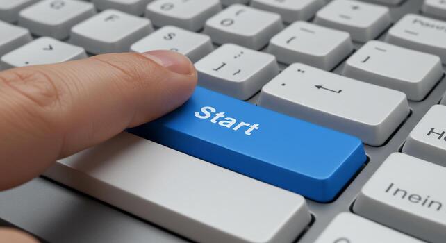 A person is pressing the start button on a computer keyboard photo