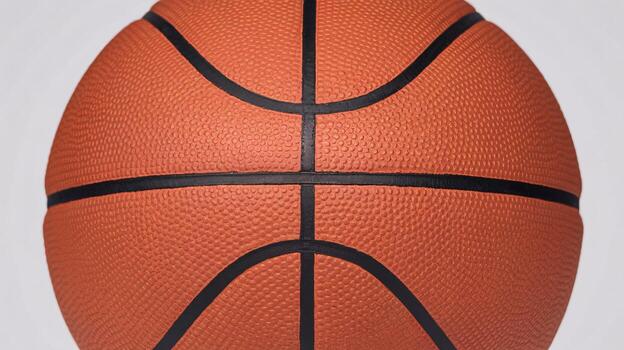 Close-up of a basketball showcasing its texture and vibrant orange color against a neutral background. photo