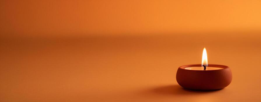 A serene candle illuminates a warm orange background, creating a calming and inviting atmosphere. photo