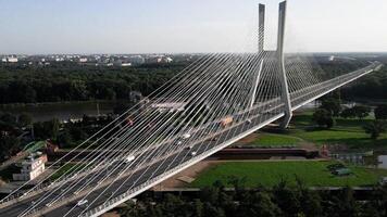 antenne visie van modern tuimelschakelaar brug over- rivier- met verkeer en omgeving velden video