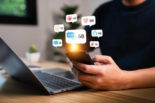 Close up of man using smartphone with social media notification icons such as like, heart, message, group, and email floating above screen, concept of digital communication and online engagement photo