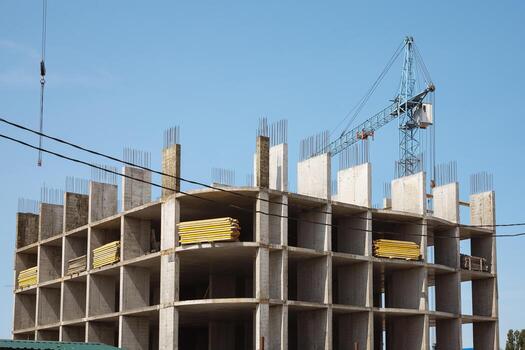 The process of building a new house. A construction site with a view of the frame of the floors and a construction crane photo