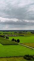 ein Aussicht von ein Grün Feld mit ein Straße und ein wenige Häuser video